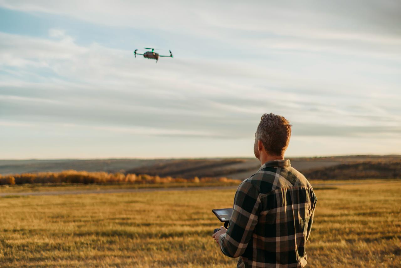 Man operating a drone to capture aerial views of rural land