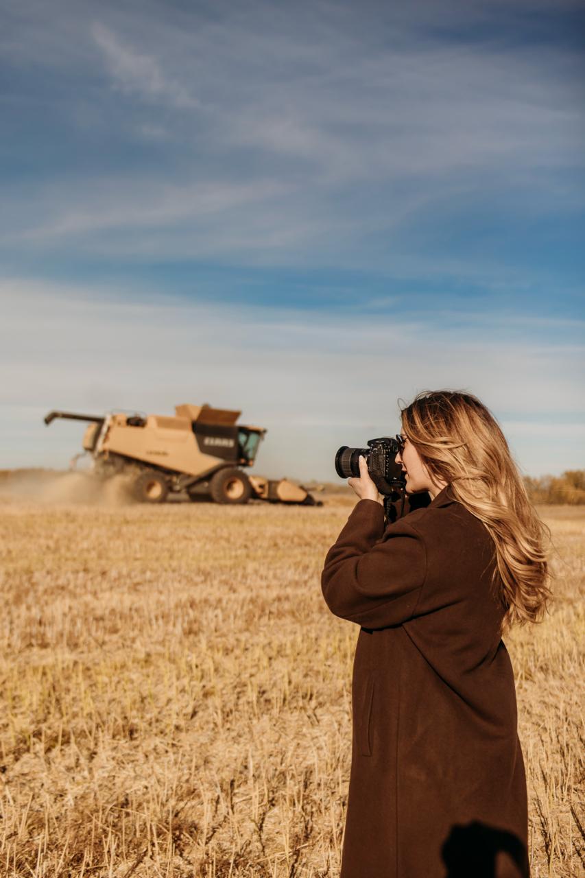 Photographer capturing rural land and hay fields from a vehicle